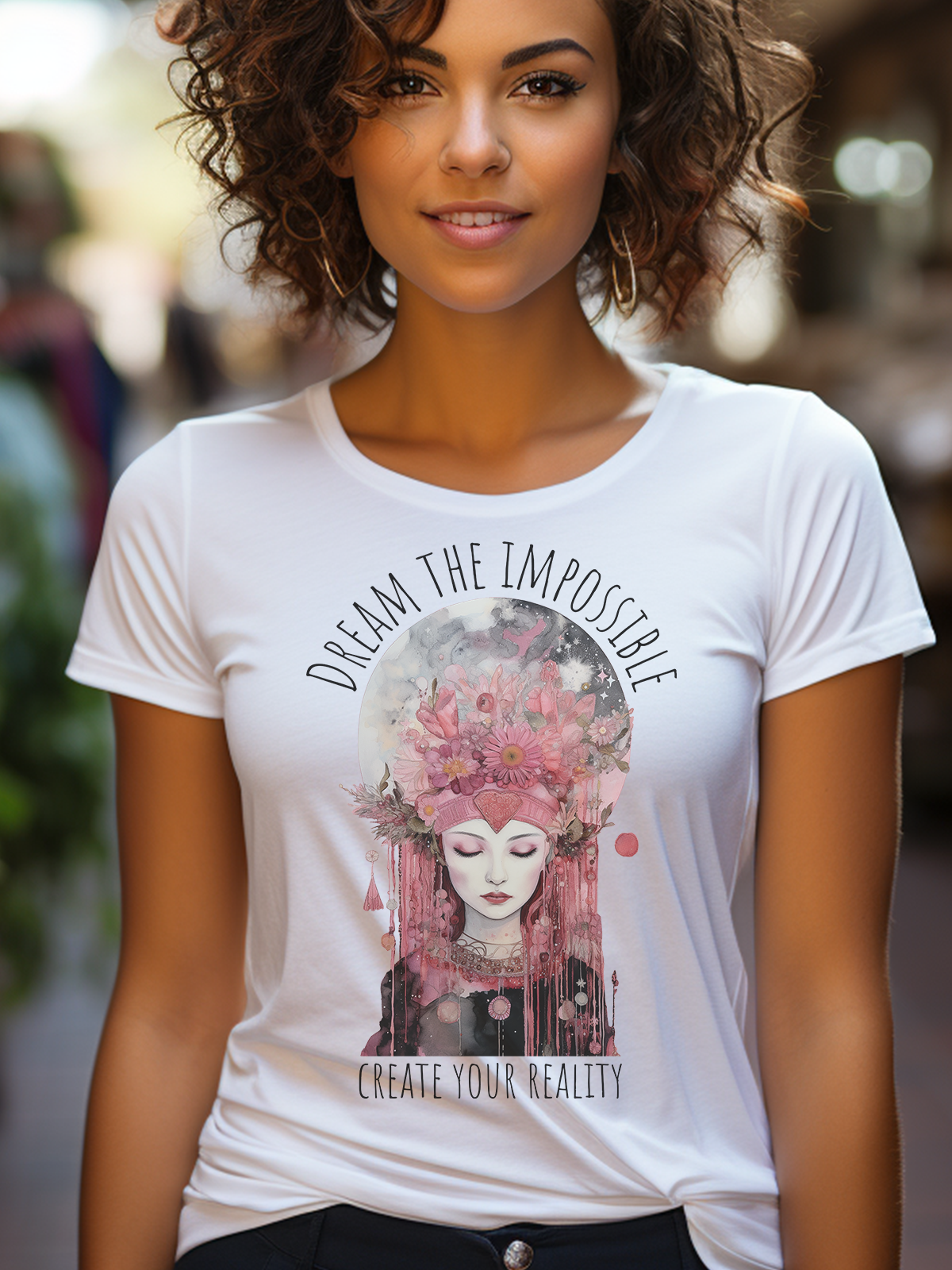 Model mit weissem bedrucktem T-Shirt. Das Motiv Mondfee umrandet mit dem Text "Dream the Impossible, create your Reality", zeigt eine romantische weibliche Figur mit geschlossenen Augen in den Tönen Rosa, Pink und Schwarz.