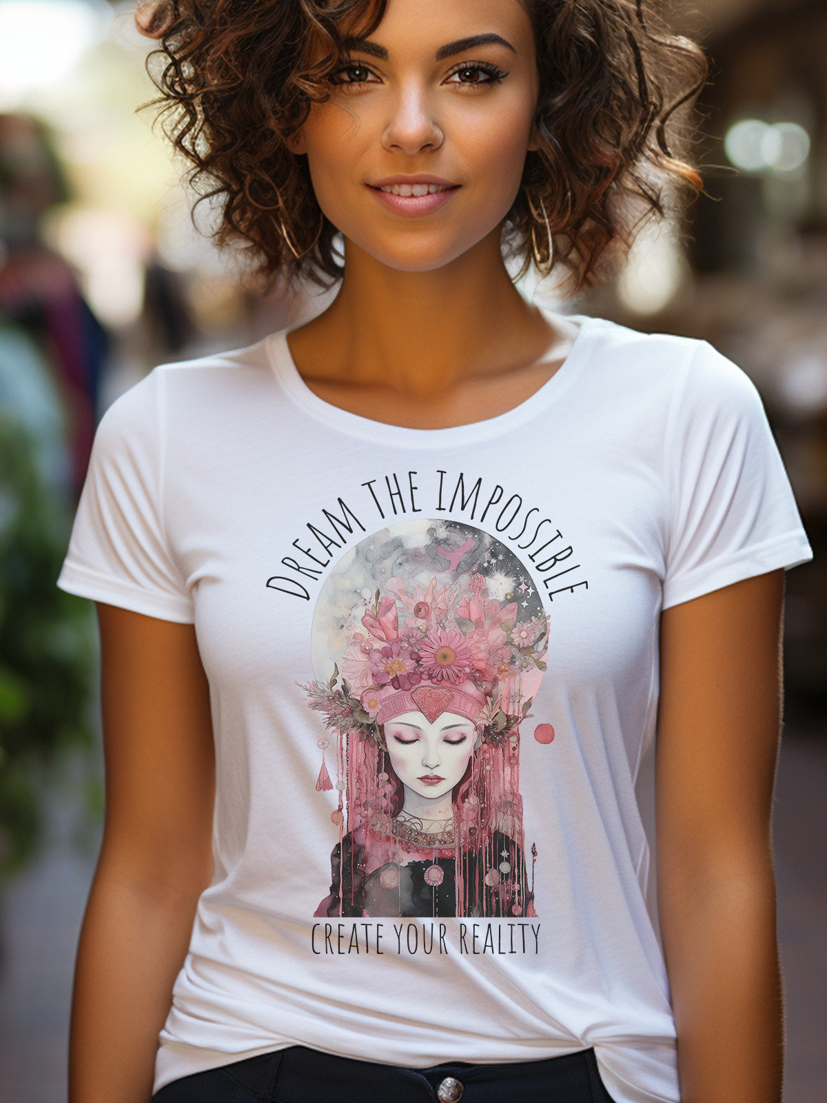 Model mit weissem bedrucktem T-Shirt. Das Motiv Mondfee umrandet mit dem Text &quot;Dream the  Impossible, create your Reality&quot;, zeigt eine romantische weibliche Figur mit geschlossenen Augen in den Tönen Rosa, Pink und Schwarz.